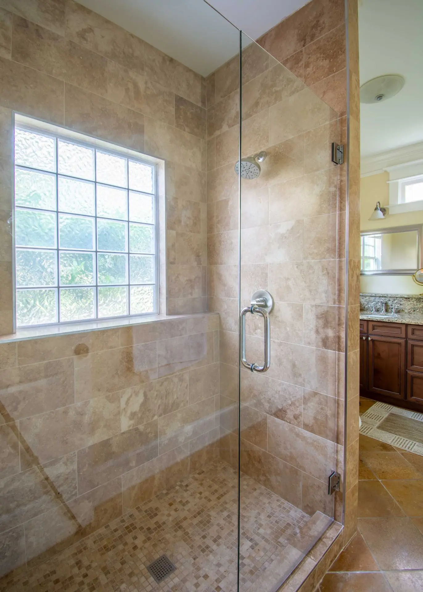Walk-in shower with travertine tile finish