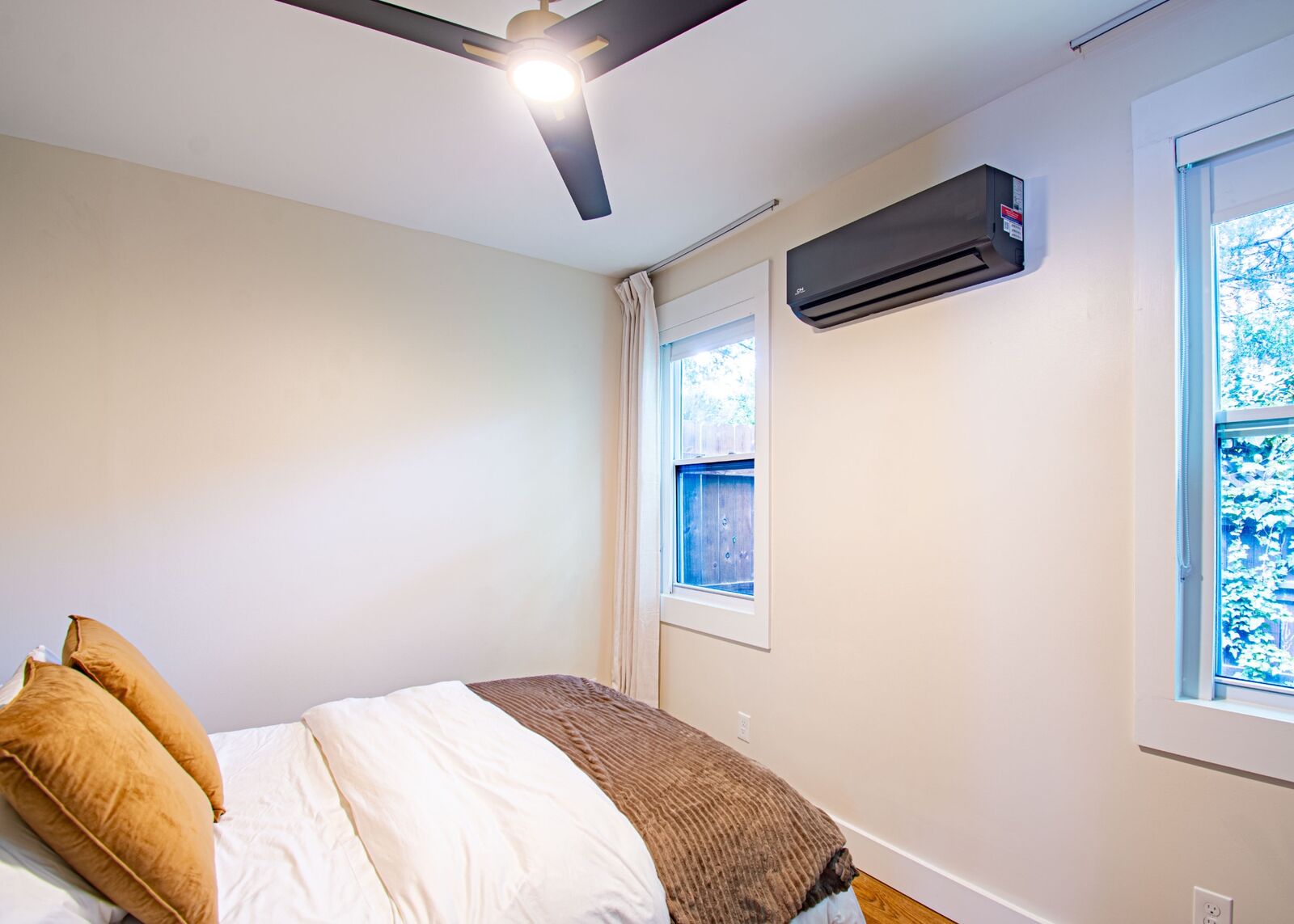 ADU bedroom with mini-split AC, ceiling fan, and large windows