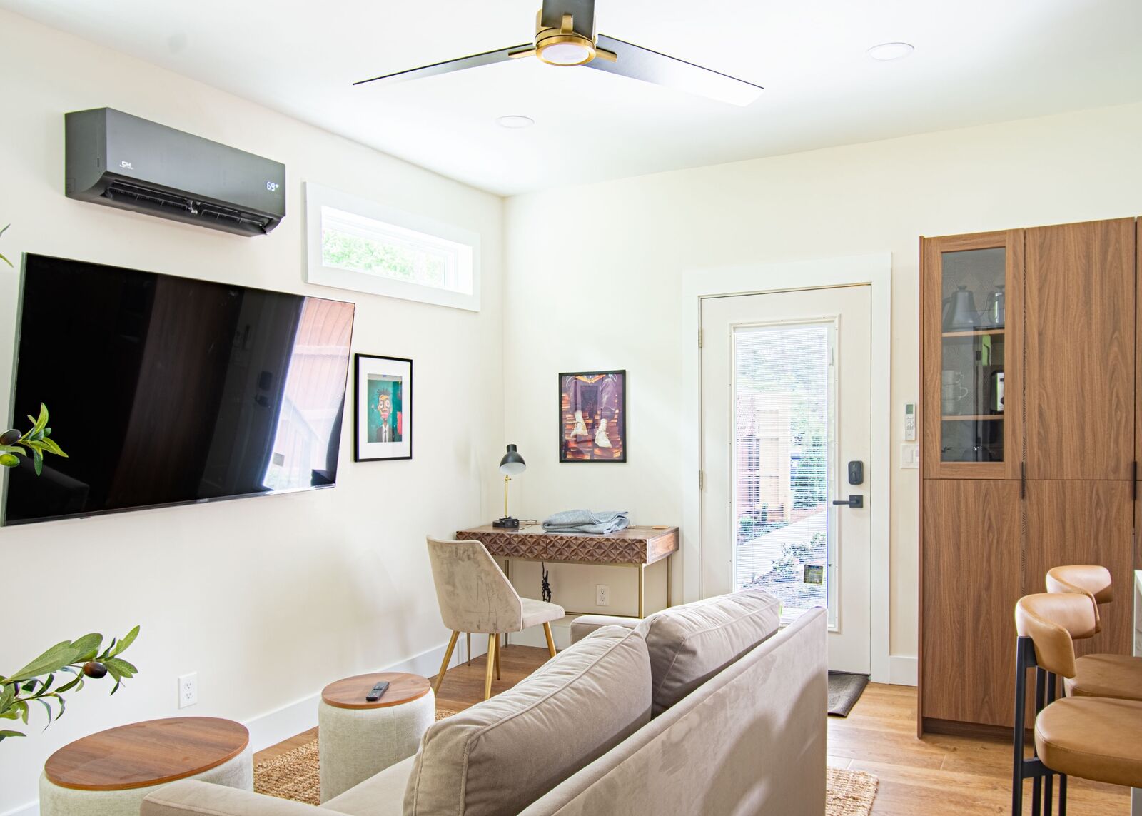 ADU workspace and lounge area with mounted TV and natural light