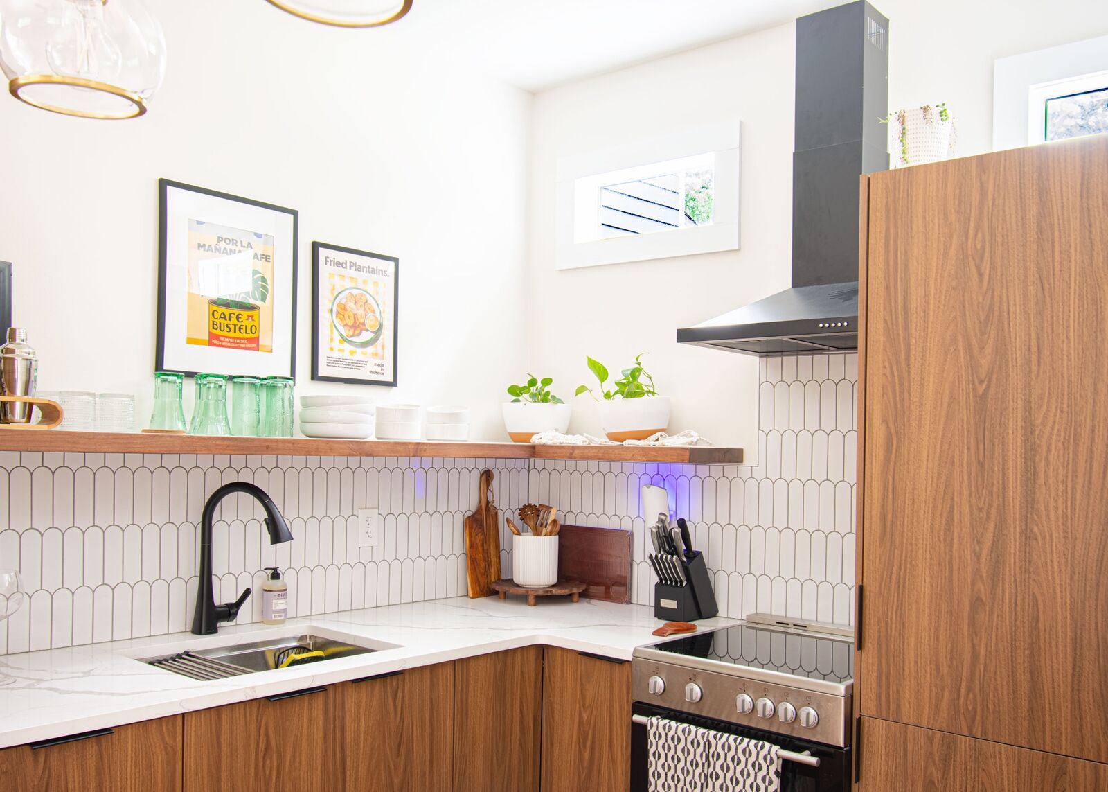 Custom walnut kitchen cabinetry with quartz counters and feather tile backsplash
