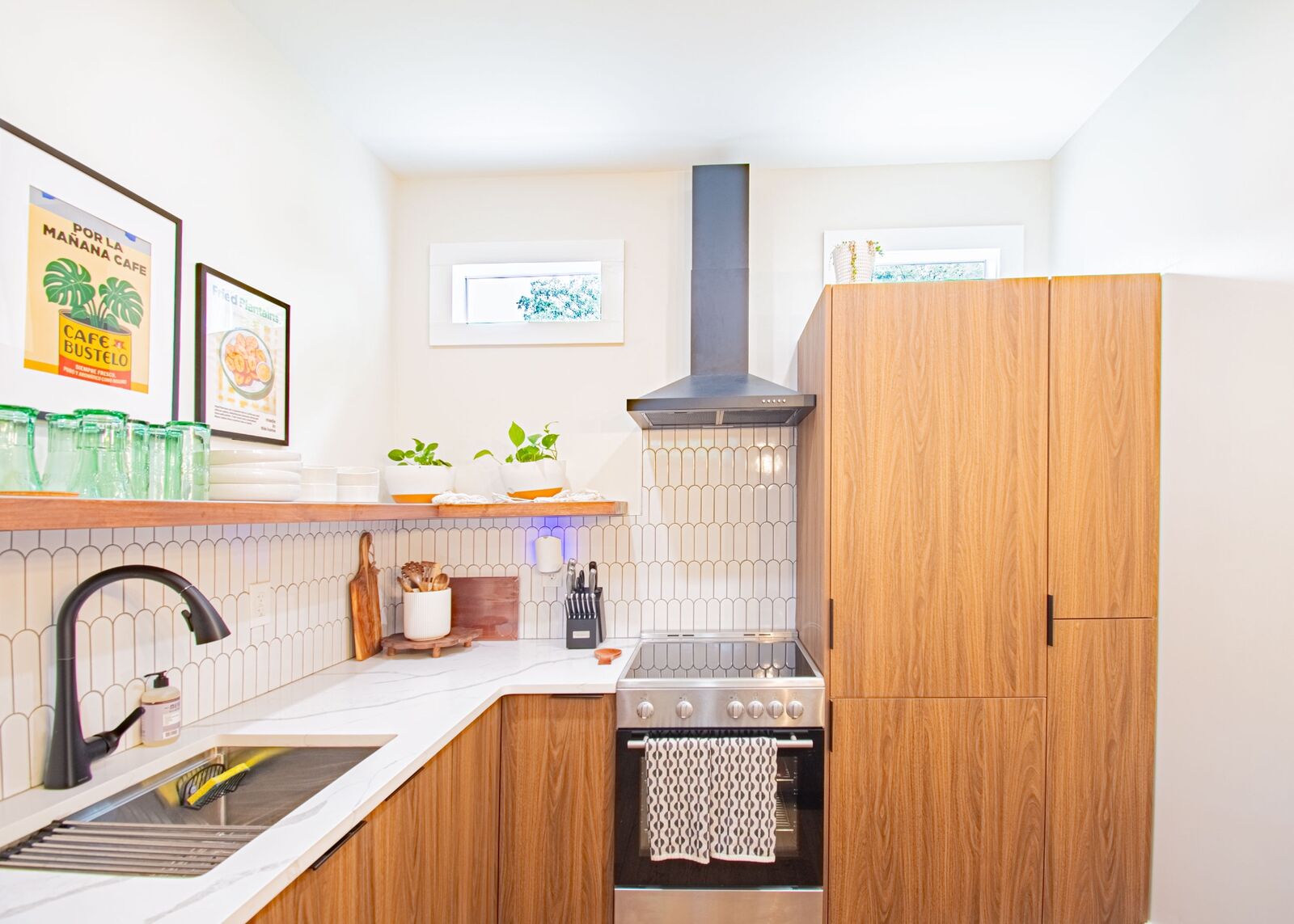 Wide view of the new ADU kitchen with range hood and pantry tower