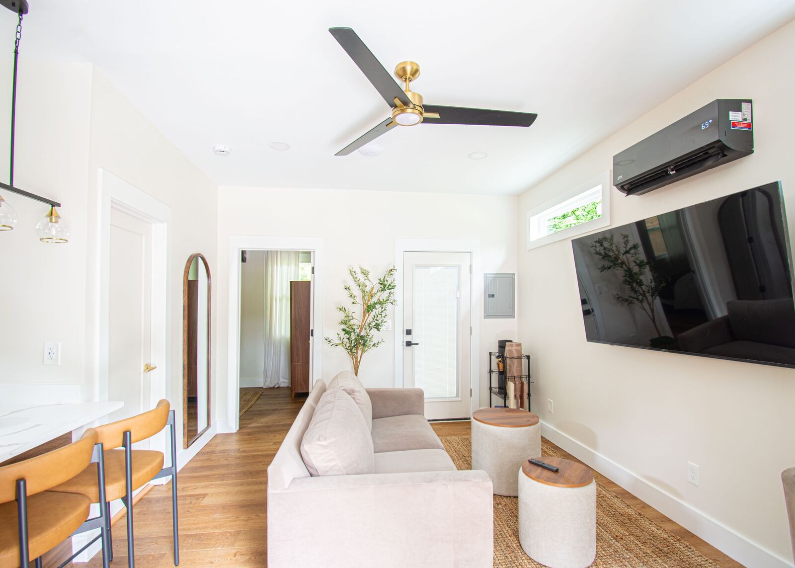 ADU living room with ceiling fan, mini-split HVAC, and wood flooring