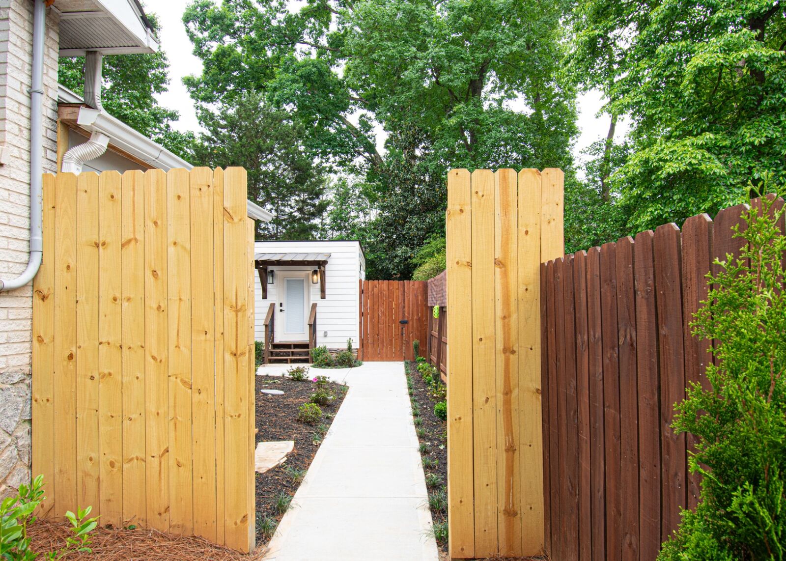 Custom cedar privacy fence and concrete walkway leading to the new ADU